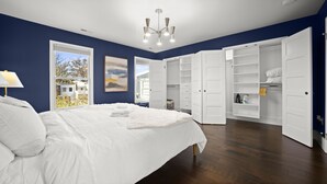 Quarto com cama grande, closet espaçoso e vista para o exterior.