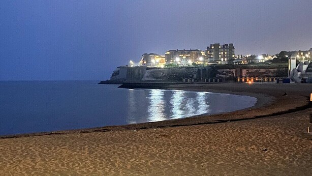A beach with a curved shoreline, a building with multiple floors in the background, and a clear sky. - Eva's Sea View 2 Bed 2 Bath Parking & NO GUEST FEES (Broadstairs)