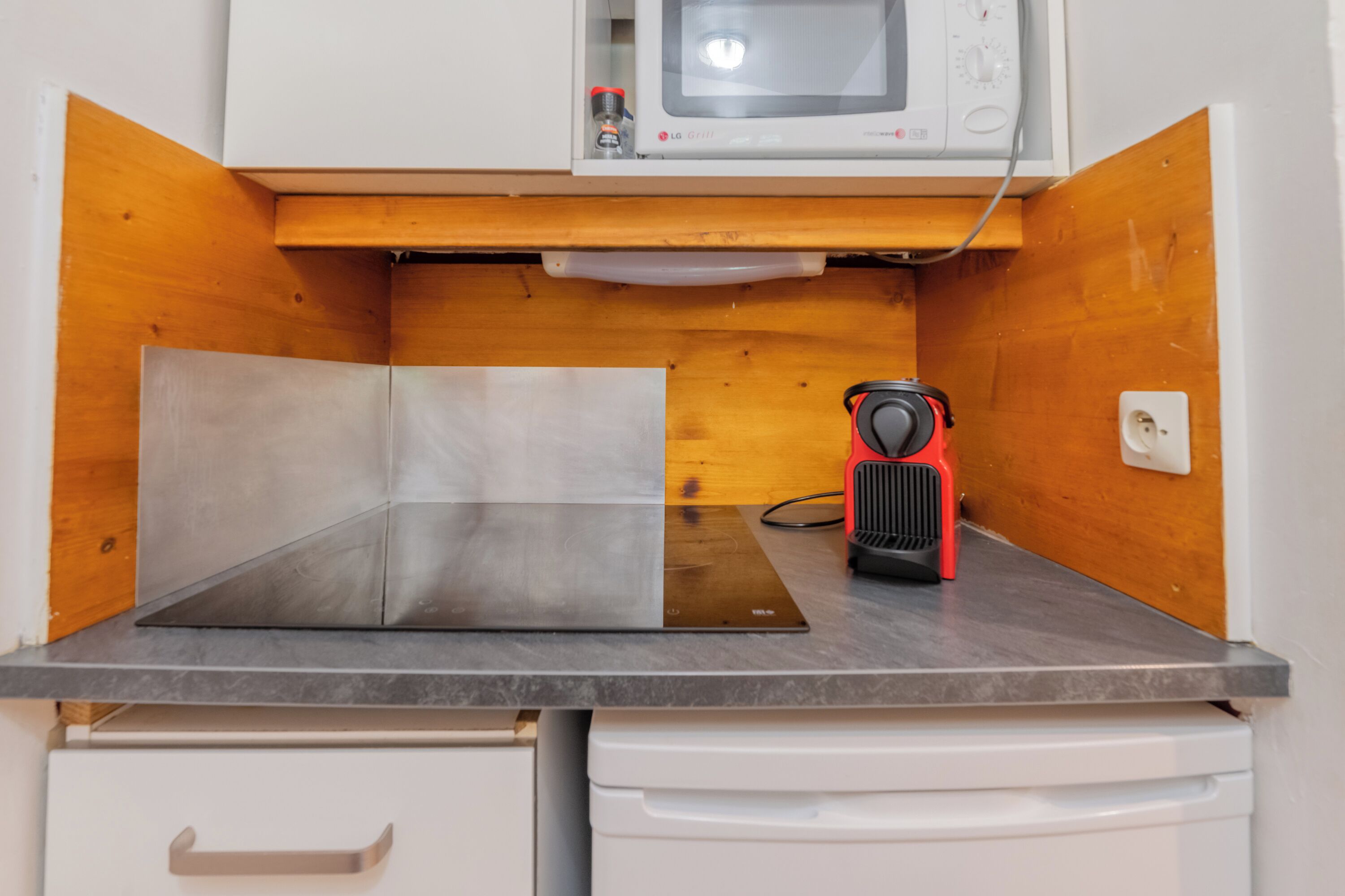 Una kitchenette equipada con microondas, tostadora y lavabo.
