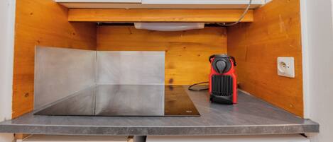 Una kitchenette equipada con microondas, tostadora y lavabo.