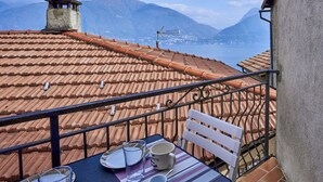 A terrace with a table set for two, overlooking a mountainous landscape. - Beautiful apartment for 3 people with A/C, WIFI, TV and balcony (San Siro)