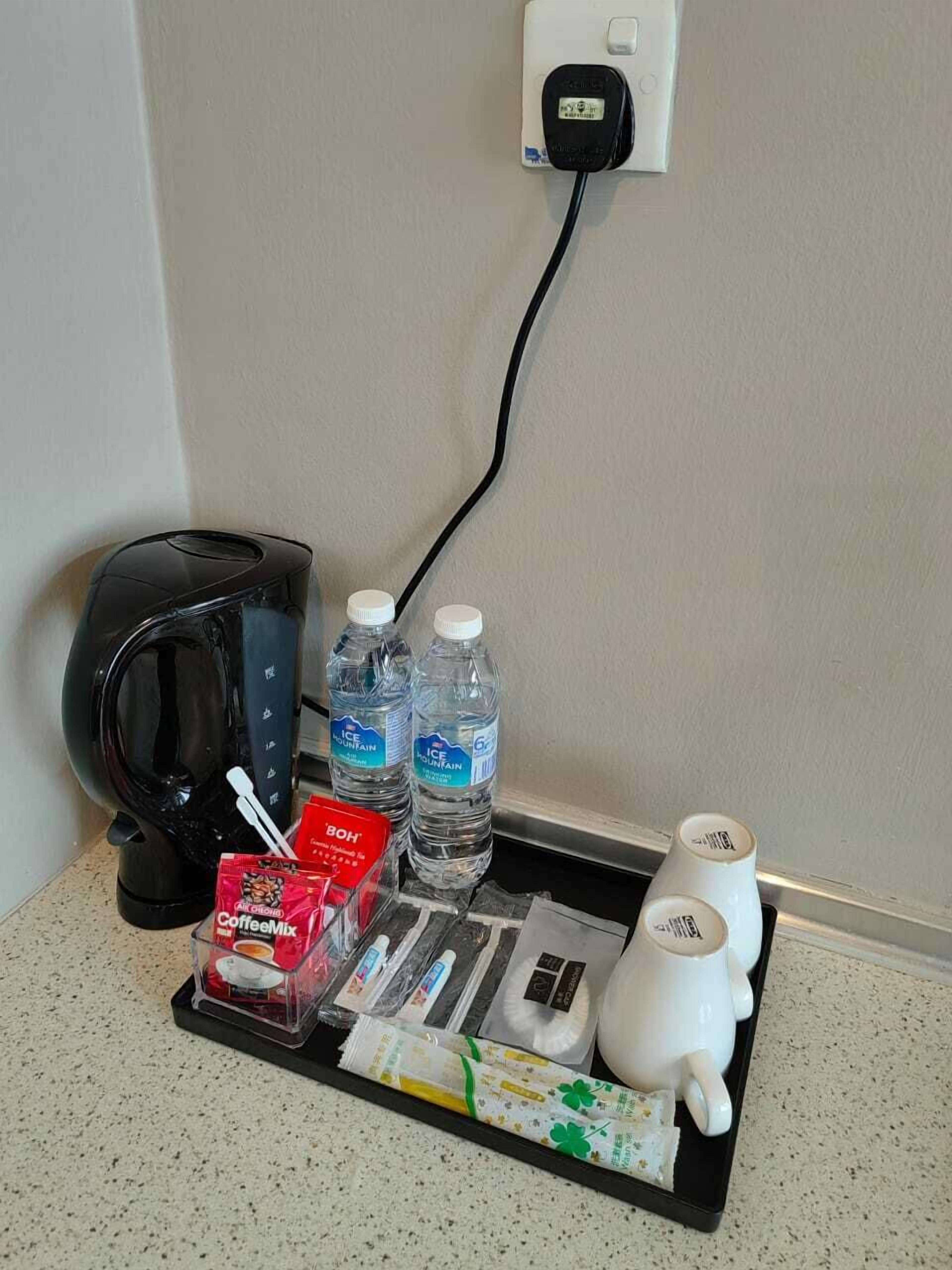 Ein Kaffeeangebot mit Kaffeemaschine, Wasserflaschen, Kaffeepulver und einem Tee-Set.