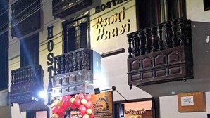 Un bâtiment sur lequel on peut lire l’inscription « Hostal Rumi Huasi », et qui possède un balcon orné de balustrades décoratives.