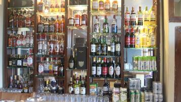 Eine Bar mit Regalen voller verschiedener Spirituosenflaschen und Gläser.