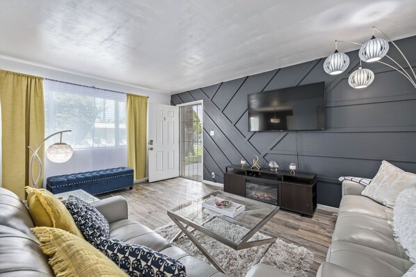 A modern living room with a sofa, coffee table, and a TV mounted on the wall. - HEART of Old Town Scottsdale!! Within walking distance to many destinations! (Scottsdale)