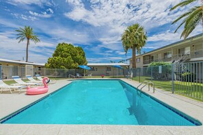 A swimming pool with lounge chairs and a pink flamingo float. - HEART of Old Town Scottsdale!! Within walking distance to many destinations! (Scottsdale)