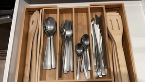 A wooden drawer with compartments containing various kitchen utensils including spoons, forks, knives, and a spatula. - Loft 654B two blocks from BART (Richmond)