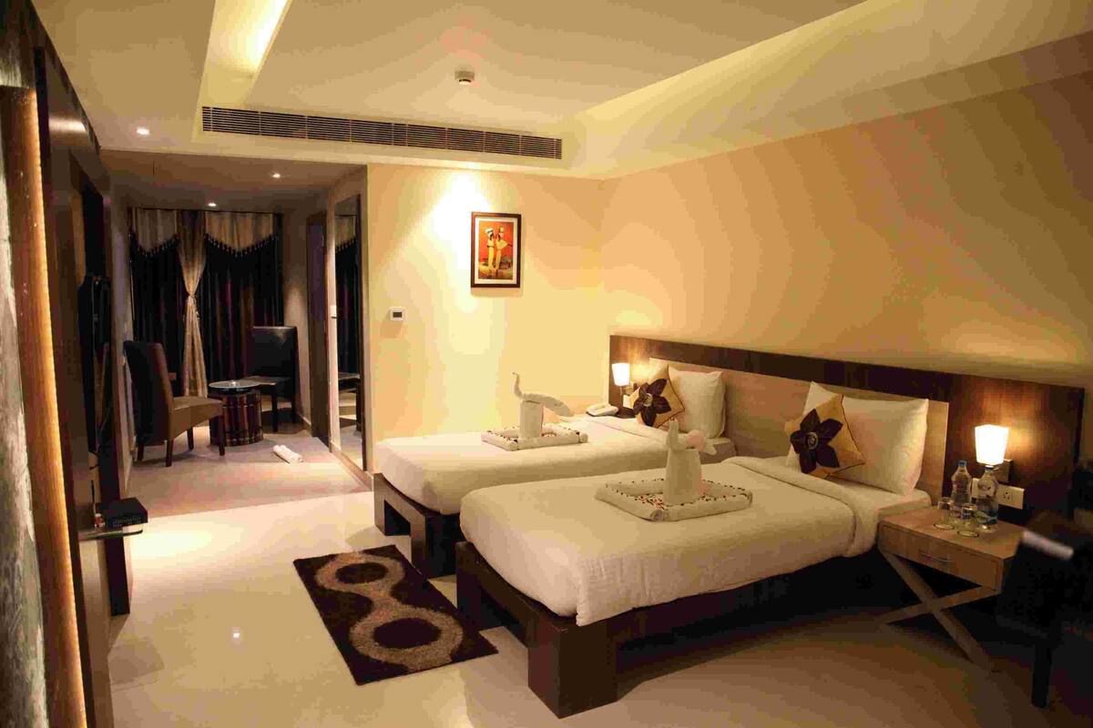 Ein Hotelzimmer mit zwei Betten, einer Sitzecke und Blick auf den Flur.