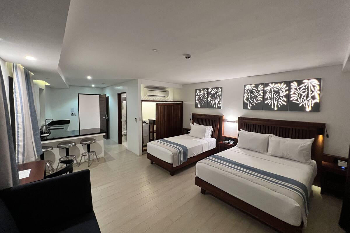 Ein Hotelzimmer mit zwei Betten, einem Schreibtisch und einem Badezimmer.