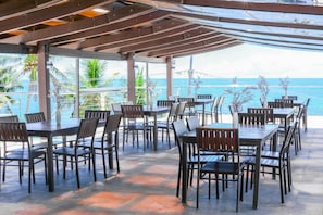 An outdoor patio with tables and chairs, overlooking a body of water. - Aira Boracay Hotel (Boracay Island)
