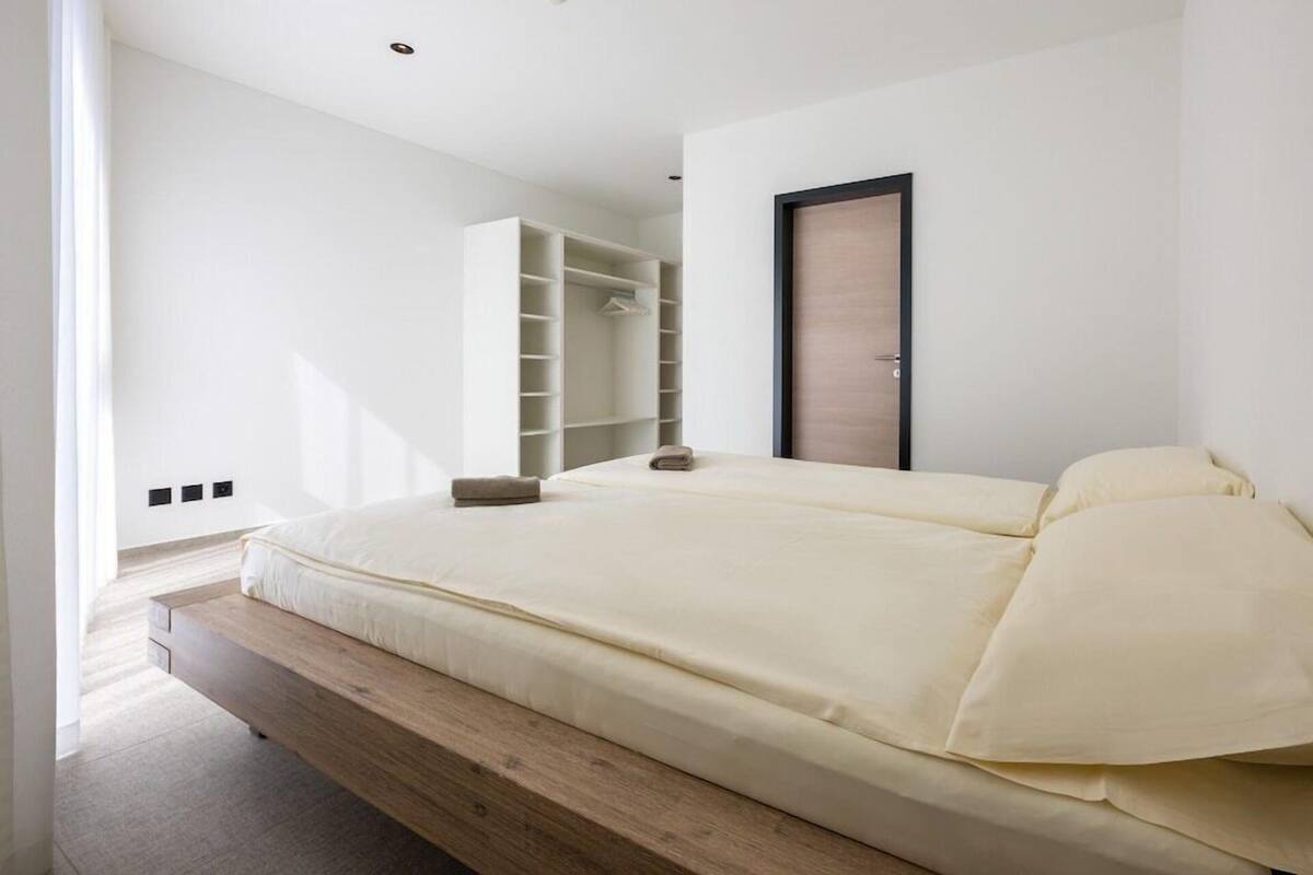 Une chambre à coucher moderne avec un lit, des étagères intégrées et une armoire.