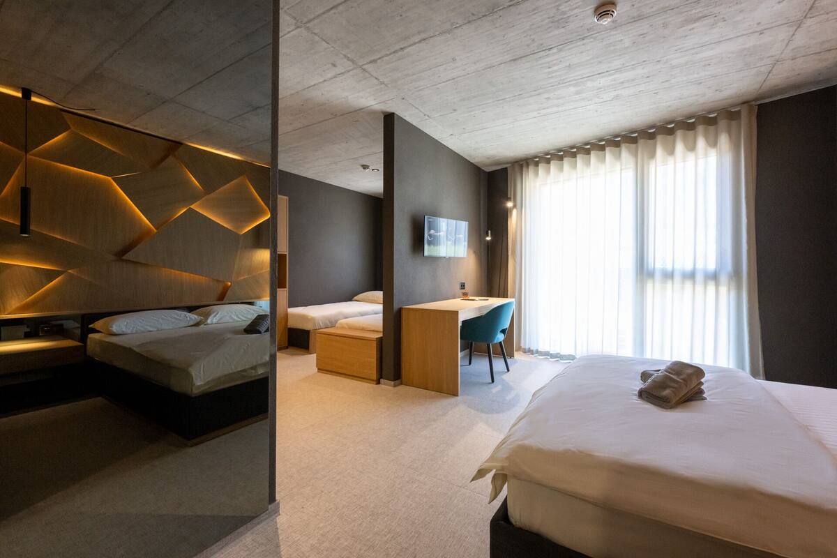 Une chambre d’hôtel moderne dotée d’un grand lit, d’un bureau et d’un coin salon.