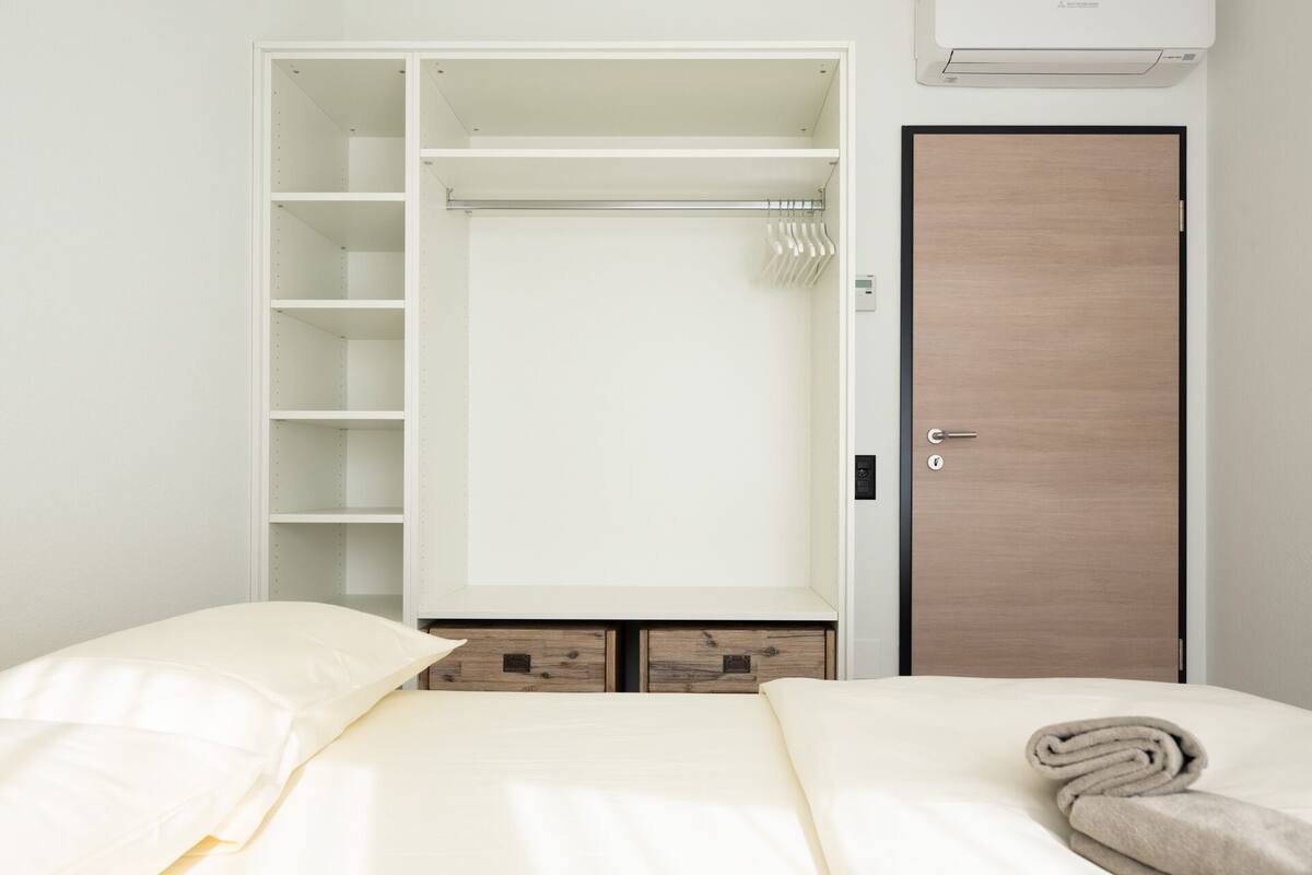 Une chambre à coucher avec un lit, une armoire et une porte.