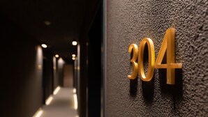 A hallway with a textured wall and a number '304' sign.