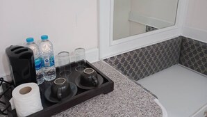 Eine Küche mit einer Granit-Arbeitsplatte, einem schwarzen Toaster, Wasserflaschen, einer Glastafel mit Tassen und einer Rolle Küchenpapier.