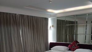 Ein modernes Hotelzimmer mit einem großen Bett, Holzboden und einem großen Spiegel.