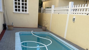 A rectangular swimming pool with a white hose and a pool cleaning device. - 3 Bedroom Private vacation home in Pereybere (Pereybere)