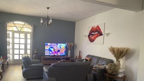 A living room with a television, sofas, a chandelier, and a large window. - 3 Bedroom Private vacation home in Pereybere (Pereybere)