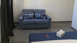 A hotel room with a bed, a sofa, and two wall art pieces. - 3 Bedroom Private vacation home in Pereybere (Pereybere)