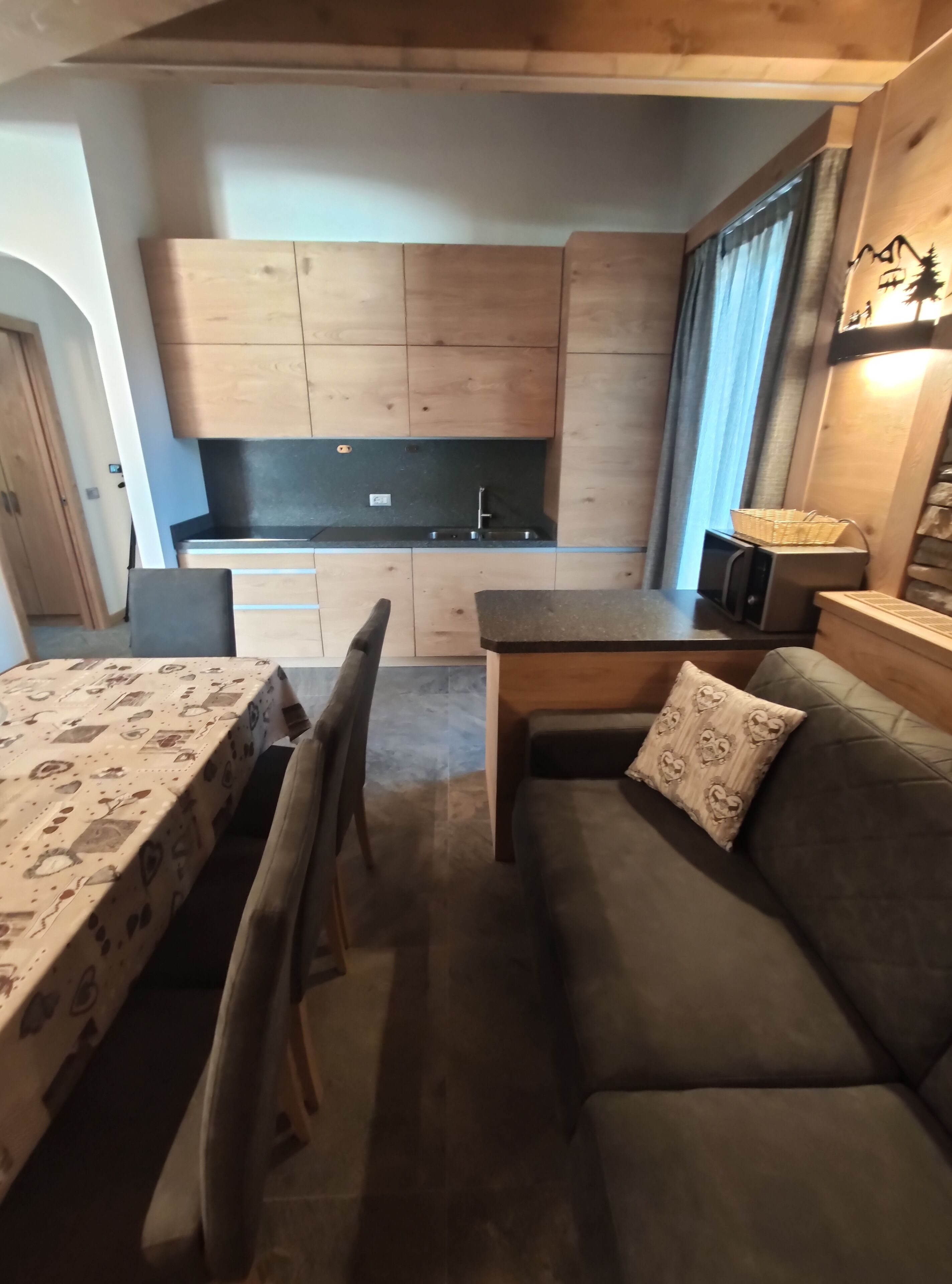 A compact living space with a kitchenette, a dining table, and a sofa.