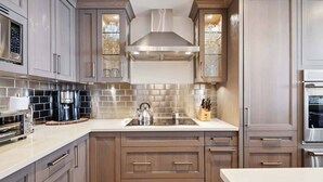 A modern kitchen with stainless steel appliances, wooden cabinets, and a tiled backsplash. - Lodge Tower 687 3BR at the base of Vail Mountain (Vail)