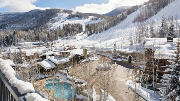 A resort with multiple buildings, a swimming pool, and a ski slope in the background. - Lodge Tower 687 3BR at the base of Vail Mountain (Vail)