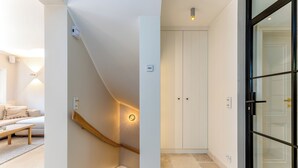 Un interno moderno con una scala, una porta bianca e una porta in vetro.