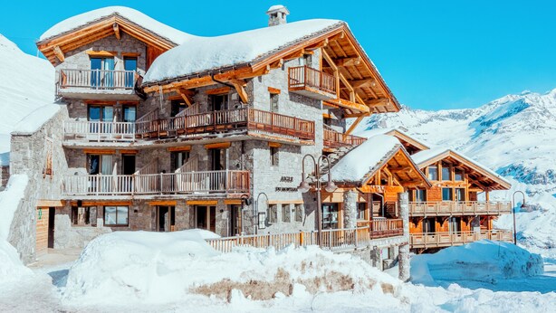 A multi-story lodge with balconies, set against a snowy mountain backdrop. - Hôtel L’Aigle du Montana by Les Etincelles (Tignes)
