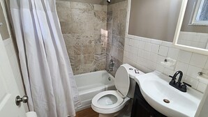 Een badkamer met een bad, toilet en wastafel.