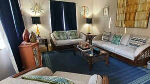 Een woonkamer met een zithoek, een salontafel en twee bijzettafels met lampen.