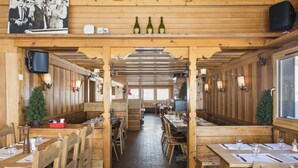 Un intérieur en bois avec des tables et des chaises, un plafond en bois et une vue par la fenêtre.