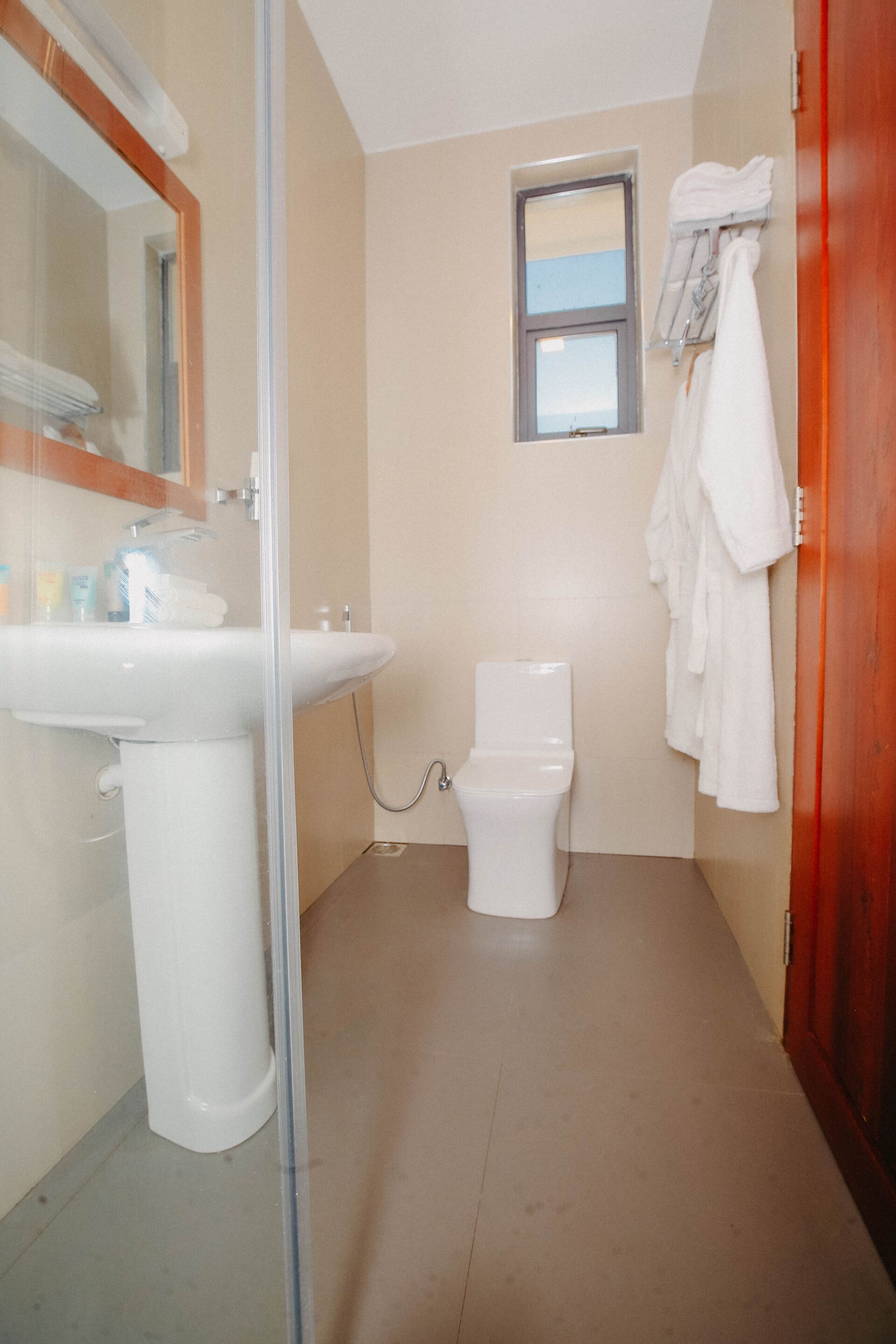 Un baño con lavamanos, inodoro y cabina de ducha de vidrio.