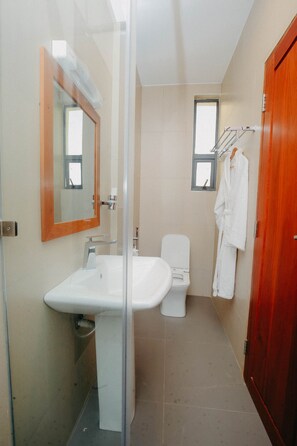 Enjoy a refreshing shower in this bathroom featuring a glass shower enclosure, a sink, and a toilet.