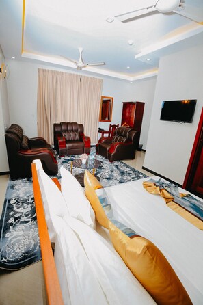 Relax in this stylish room with a large bed, two sofas, and a flat-screen TV.