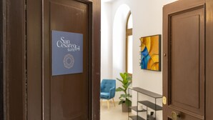 Een hotelingang met een bord waarop 'San Cesareo Suite 64' staat.