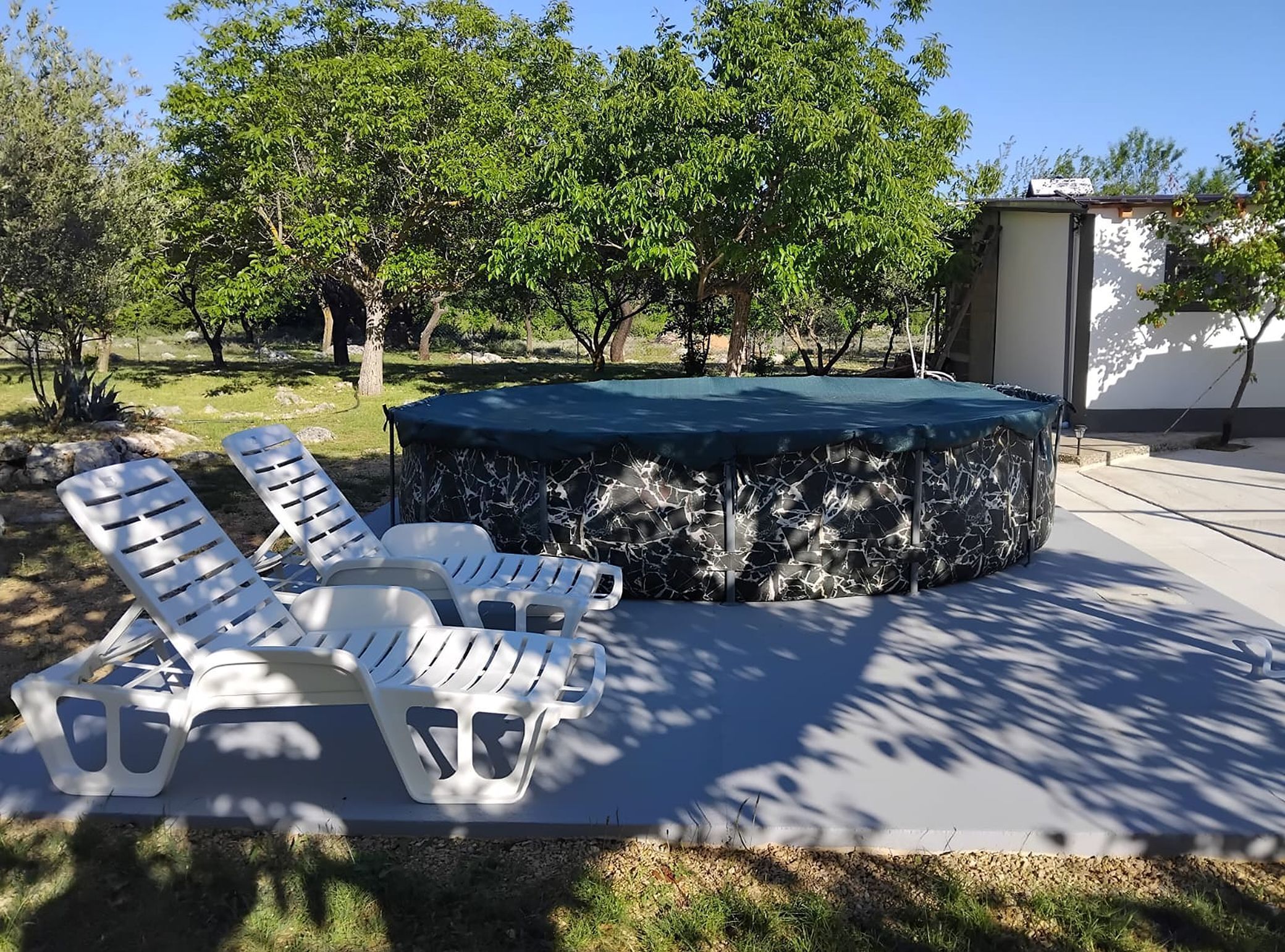Ein Pool mit Liegestühlen und einer überdachten Lounge.