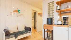 A cozy room with a sofa, a coffee machine, and a kettle on the counter.