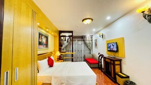 Una habitación de hotel con cama, televisión, escritorio y armario.