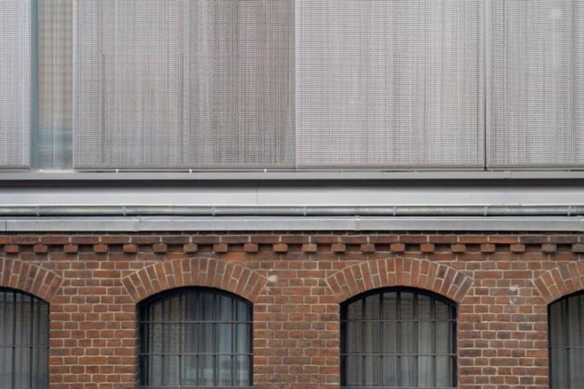 A brick building with arched windows and a metal awning.