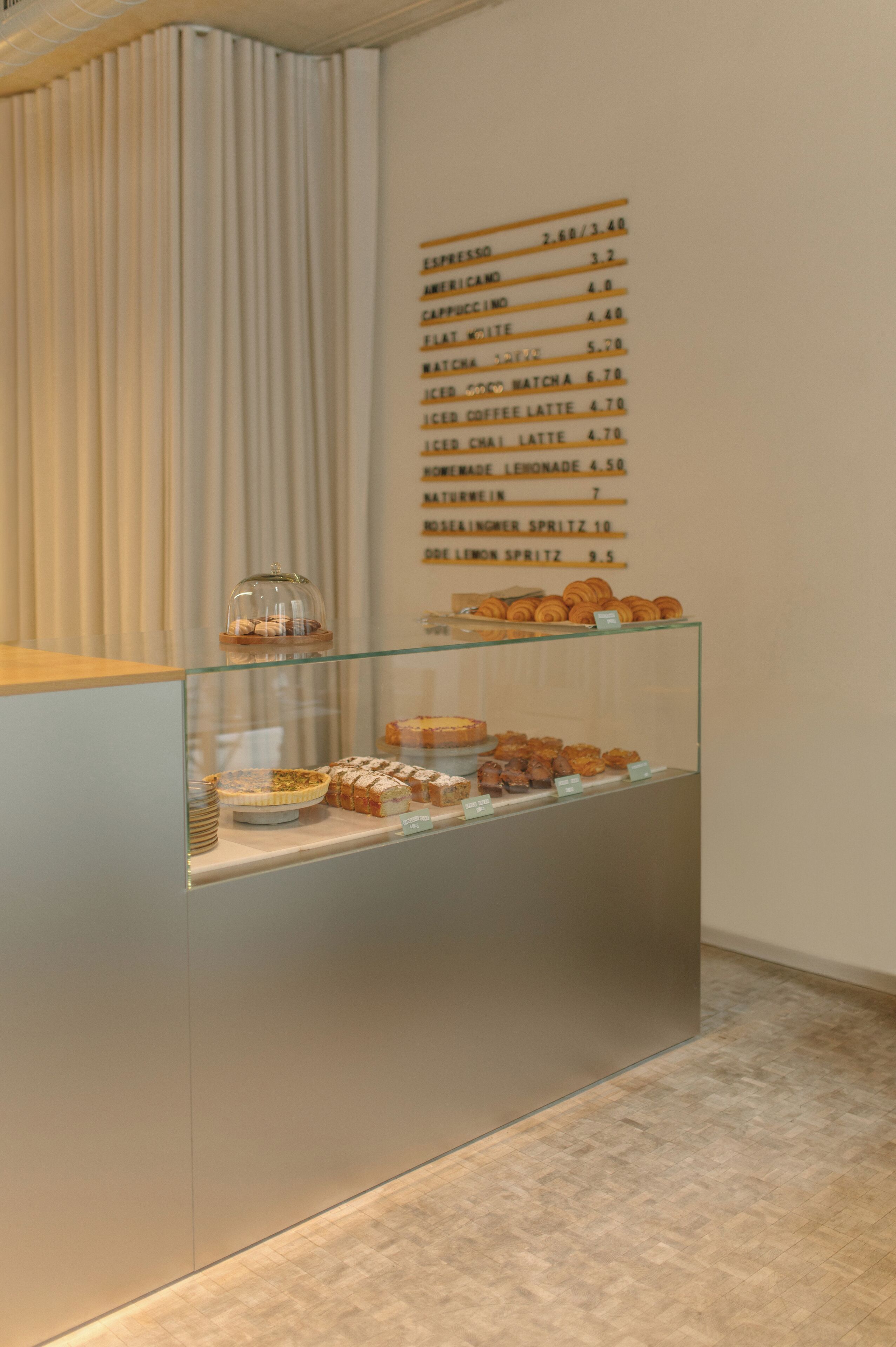 Mostrador de cafetería con un menú que muestra diversas opciones de café y postres.