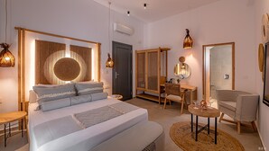 A modern bedroom with a large bed, bedside tables, a desk, and a chair. - Le Palme Mykonos (Mykonos)