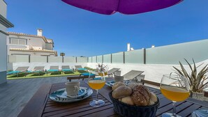 A terrace with a table set for breakfast, including bread, a cup, and wine glasses. - ★Luxury Villa walking distance Galé Beach, Albufeira (Albufeira)