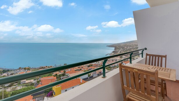 A balcony with a view of the sea and a town below. - Santa Cruz Apartment (Santa Cruz)