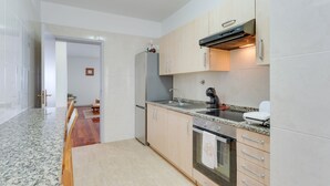 A modern kitchen with granite countertops, stainless steel appliances, and light wood cabinets. - Santa Cruz Apartment (Santa Cruz)