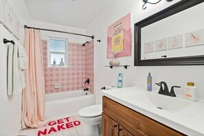 A bathroom with a bathtub, toilet, and sink.
