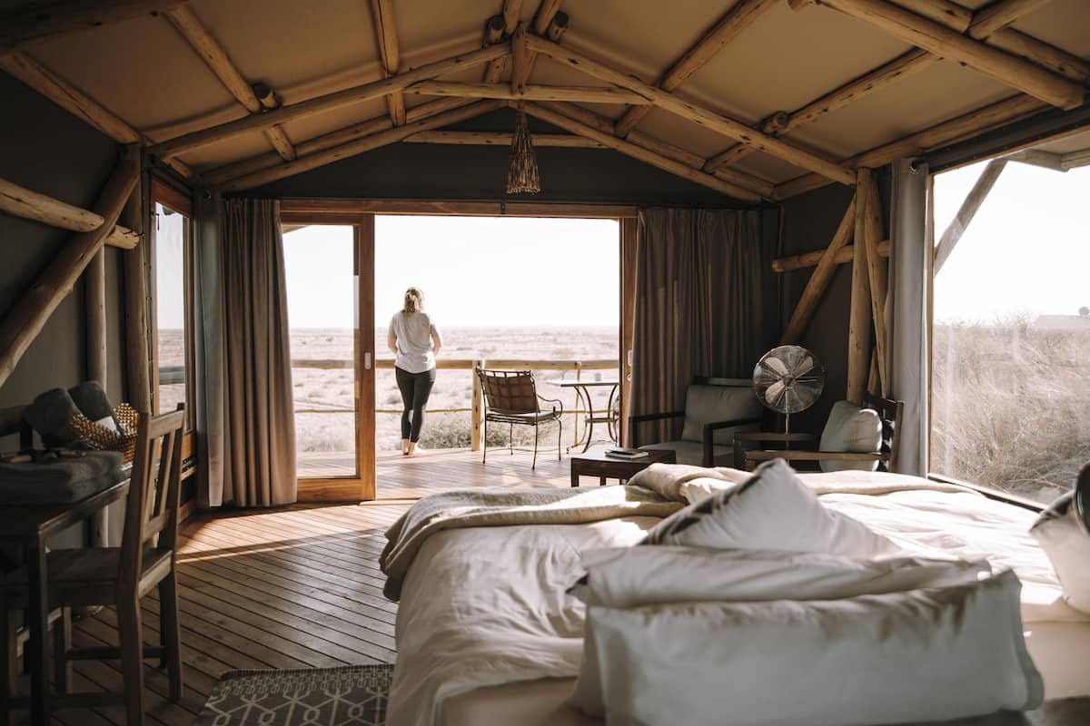 Une chambre avec un lit, un ventilateur, une table et vue sur la plage.