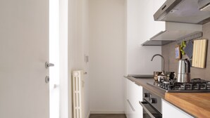 A modern kitchen with white cabinets, a wooden countertop, a built-in oven, and a stainless steel range hood. - Groovy Apartment: nice, modern and quiet house in the heart of Milan - 4 guests  (Milano)