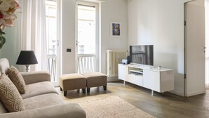 A modern living room with a sofa, ottoman, TV, and white cabinet. - Groovy Apartment: nice, modern and quiet house in the heart of Milan - 4 guests  (Milano)