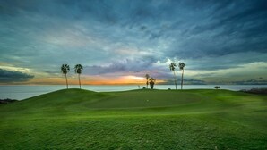 A golf course with a view of the ocean at sunset. - Elegant Villa with private pool and ocean view (CN)