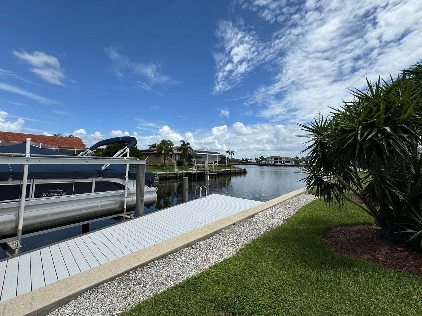 Ein Yachthafen mit Anlegesteg, ruhigem Wasser und blauem Himmel.